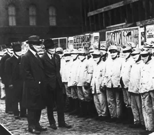 Officials wearing gauze masks inspect Chicago street cleaners for the flu, 1918